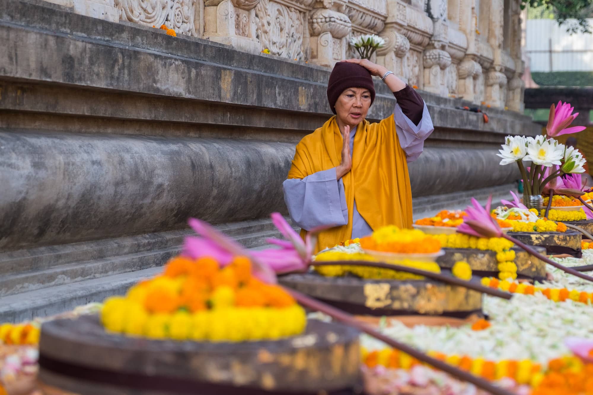 A monk prays offers prayers to the lotus carvings which represent the footsteps of the Buddha 