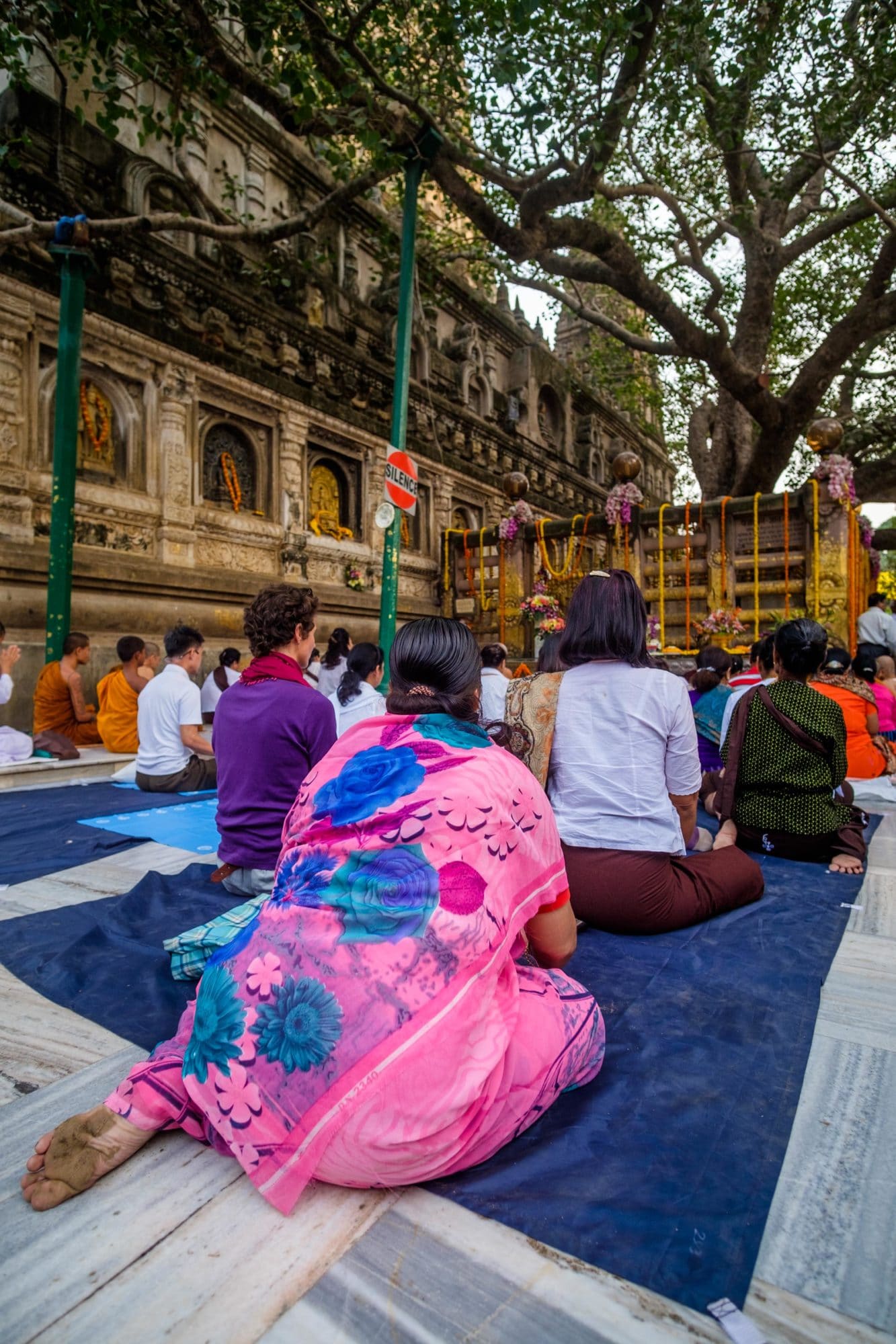 Pilgrims meditate before the Bodhi Tree in Bodhgaya